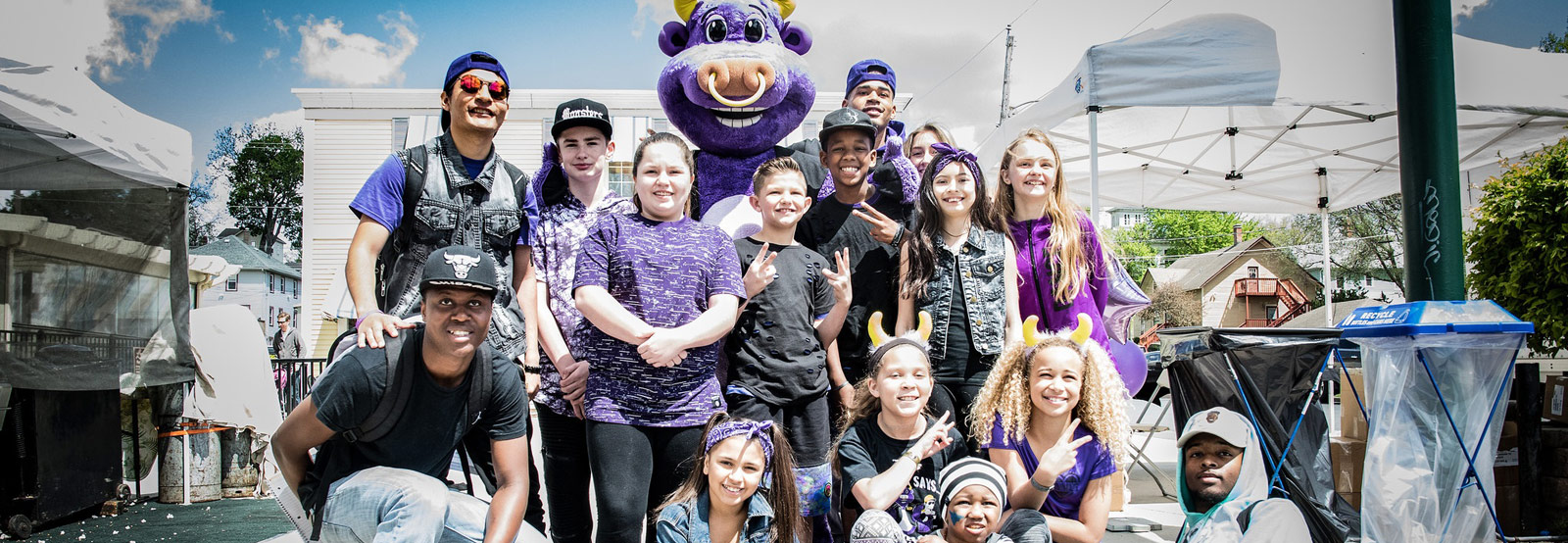 Photo showing Pete the Purple Bull with members of Reflex Dance and school kids from the Quad Cities